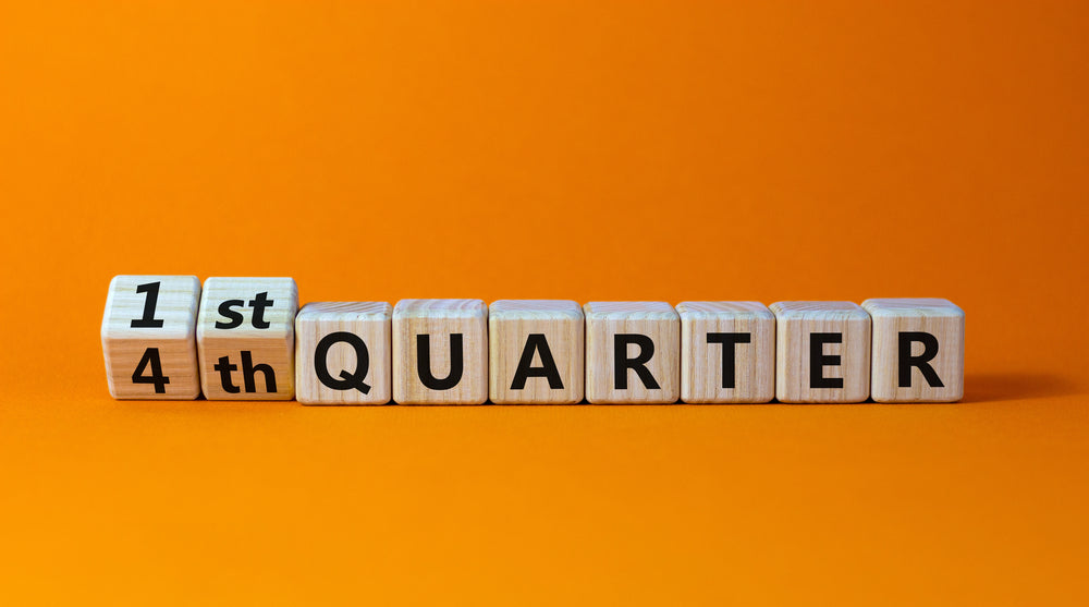 Wooden letter blocks spell "QUARTER" while a cube shifts from "1st" to "4th" on an orange background.