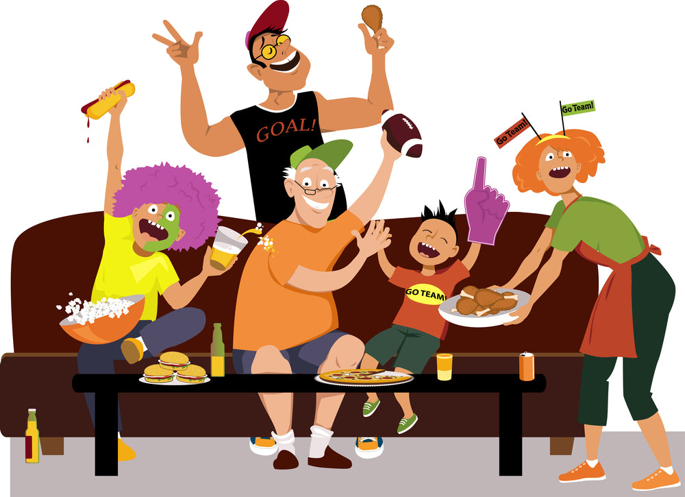 Group of enthusiastic fans cheering on a couch, waving a foam finger and holding snacks and drinks during a lively living-room viewing party.